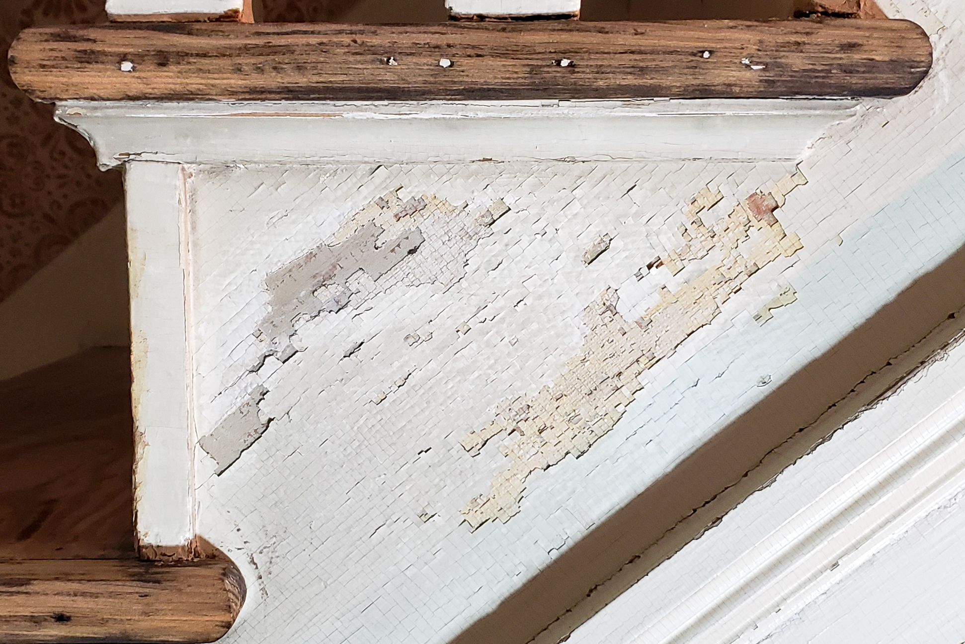 A close up of the chipping paint on the stringers of the antique staircase