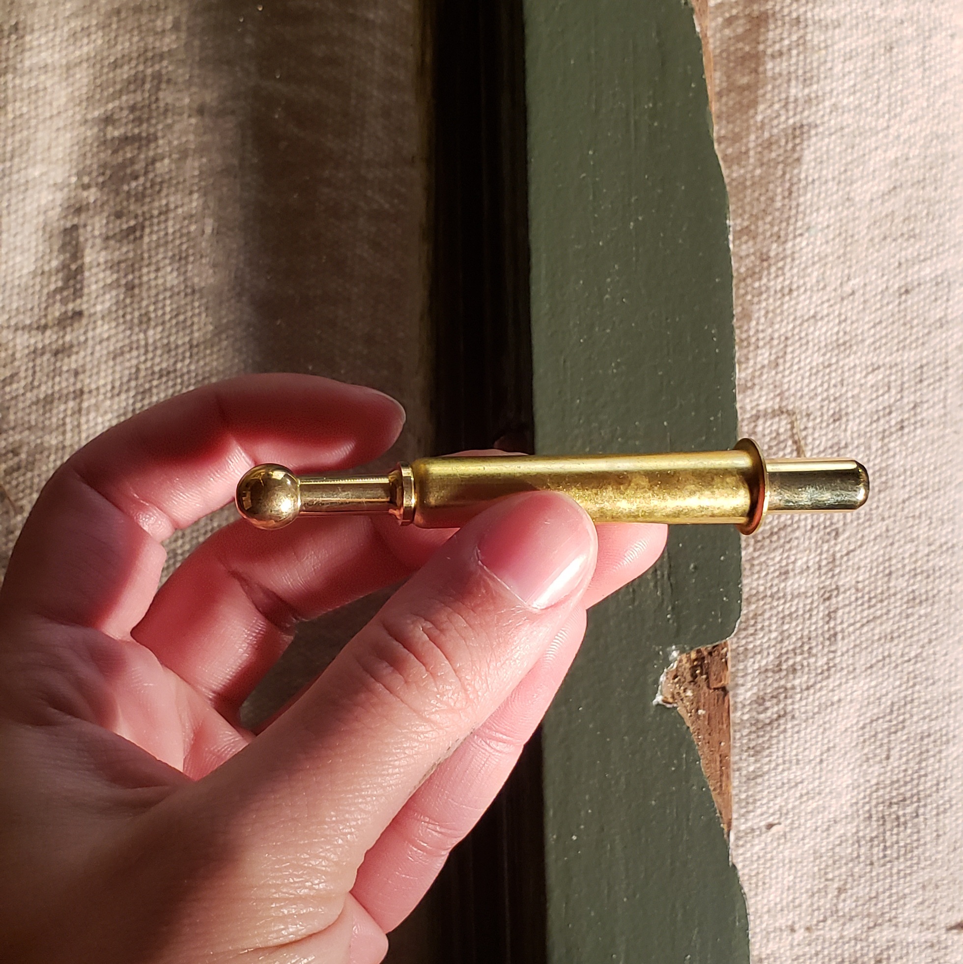 Unlacquered Brass Sash spring bolt with circular end purchased from Kilian's Hardware